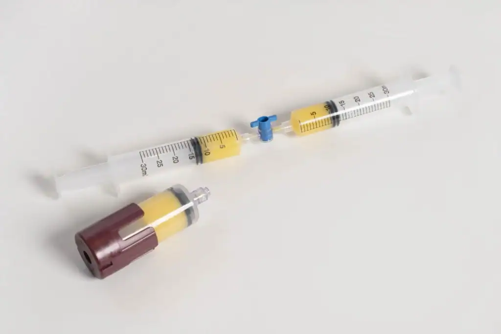 Lipo-Pro device kit Medical syringe with yellow medication and attached vial, used for precise drug delivery in medical settings.