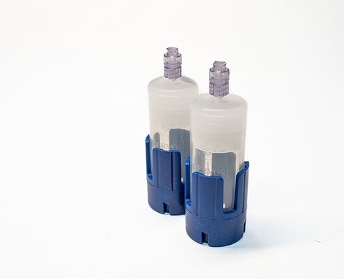 Single-use medical infusion pumps with blue holders, used for safe drug delivery in clinical settings.